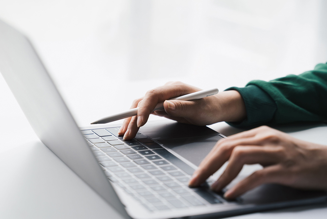 A person working on a laptop, only their hands are present